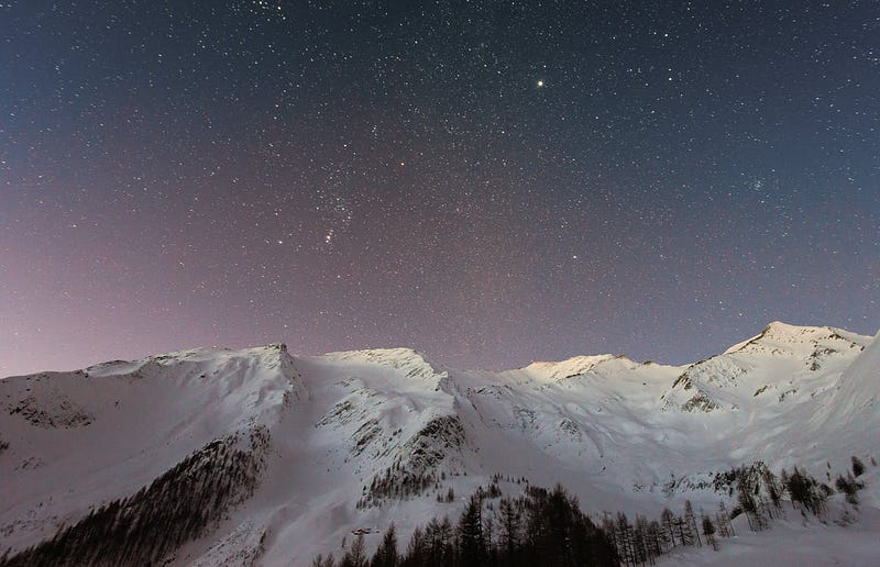 Snowy mountain landscape under a starry sky